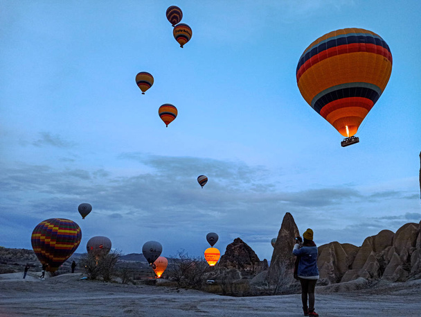 Colorful Hot Air Balloons flying over Cappadocia early morning at winter with dark morning in Turkey - Valokuva, kuva