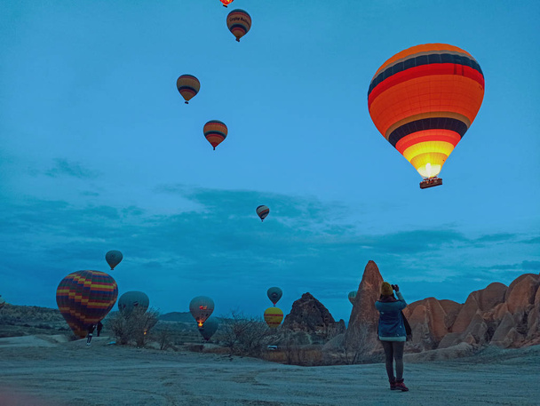 Colorful Hot Air Balloons flying over Cappadocia early morning at winter with dark morning in Turkey - Foto, Imagem