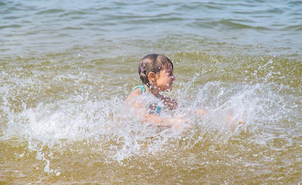 Ребенок тонет в воде в море. Селективный фокус
. - Фото, изображение
