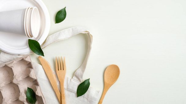 Eco friendly cotton bag, bamboo cutlery set, biodegradable paper utensils, egg carton and green leaves. Zero waste, plastic free concept. Sustainable lifestyle - Foto, Bild