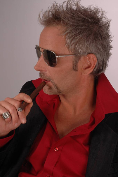 portrait of a beautiful mature man in sunglasses and cigar - Fotografie, Obrázek