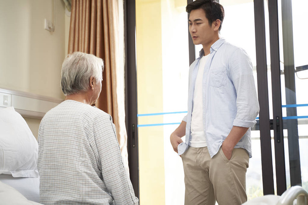 азіатський дорослий син відвідує батька в лікарні або будинку престарілих
 - Фото, зображення