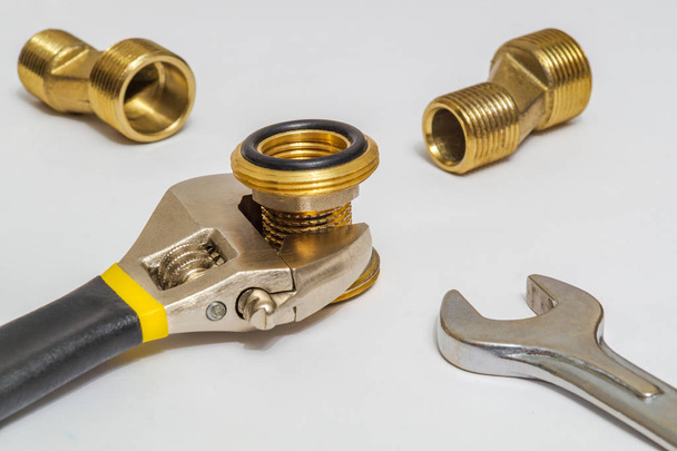 Set of brass fittings and tool is often used for water and gas installations on gray background - Photo, Image