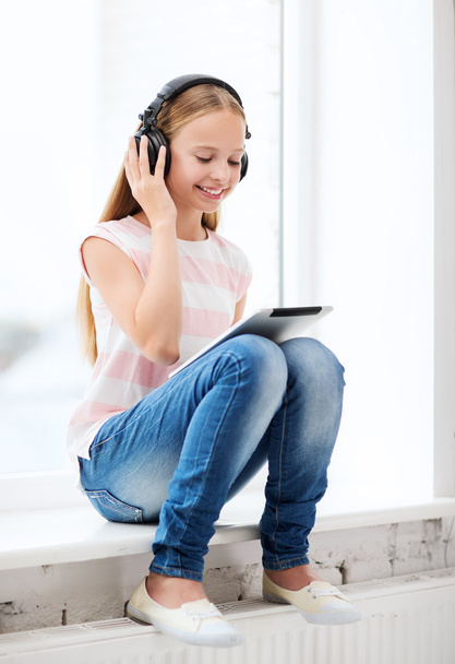 Girl with tablet pc and headphones at home - Foto, immagini