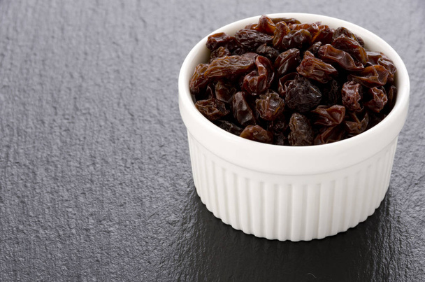 Raisins de cocotte blanche sur fond de pierre noire
 - Photo, image
