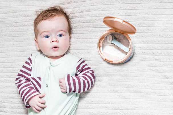 baby is lying near a can of infant formula - Foto, immagini