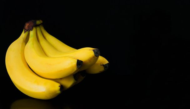  Bananen sind auf schwarzem Hintergrund isoliert. Kopierraum. - Foto, Bild