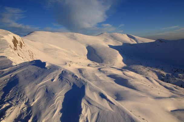 The bright blue sky above the snow-covered slopes of the mountai - Valokuva, kuva