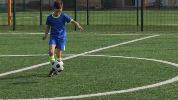 Jonge voetballer voorwaarts nemen pass en scoren doelpunt - Video