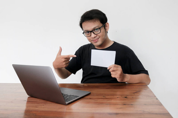 Asian man holding white sheet of paper working in studio - Φωτογραφία, εικόνα