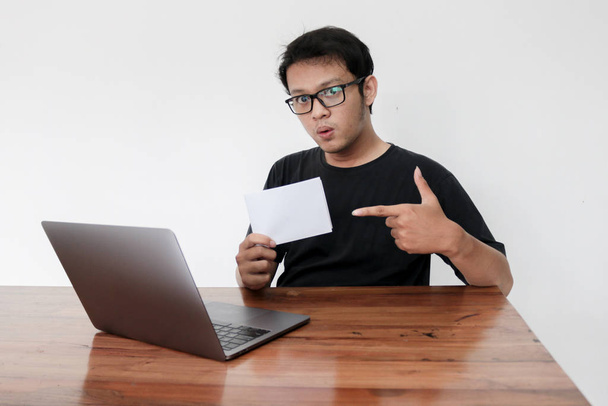 Asian man holding white sheet of paper working in studio - Foto, Imagen