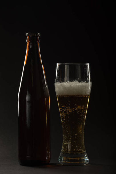 Golden beer in a bottle and in a glass and snack nuts, squid and - Photo, Image
