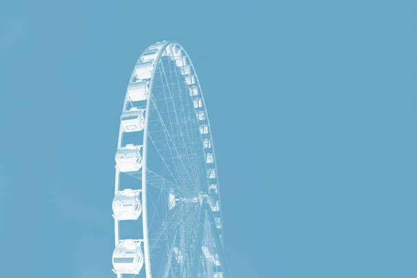 Roda gigante branca em um fundo de cor azul cinza profundo. Conceito mínimo. Espaço de cópia
 - Foto, Imagem