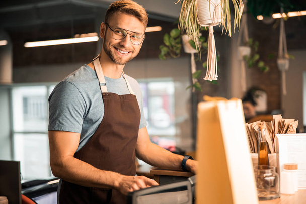 Smiling barista looking at camera in coffee house - Photo, Image