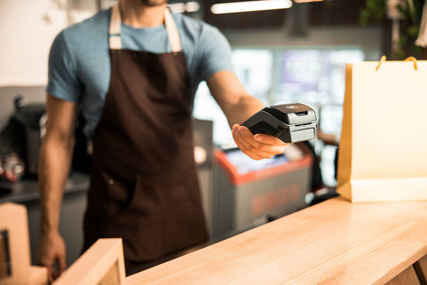 Cropped photo of waiter in apron with card reader - Fotografie, Obrázek