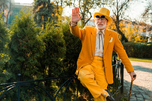 Happy old man in a funny suit in the park - Photo, Image