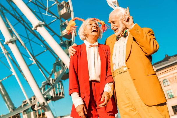 Funny elderly couple walking near ferris wheel - Foto, Imagem
