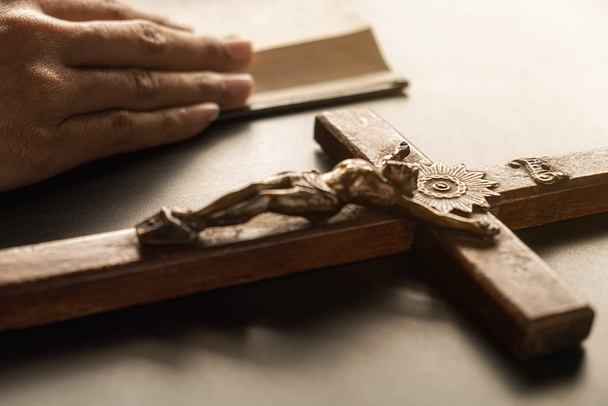 Femme chrétienne priant main dans la main sur la sainte Bible et la croix de bois. Femme prient pour la bénédiction de Dieu pour souhaiter avoir une vie meilleure et croire en la bonté. - Photo, image