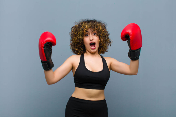 young pretty sports woman wearing fitness clothes and boxing gloves - Фото, изображение