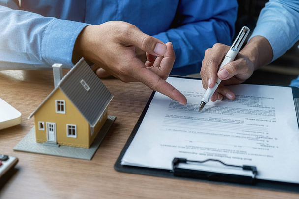 Model domu z agentem i klientem omawiającym umowę kupna, ubezpieczenia lub pożyczki nieruchomości lub nieruchomości. - Zdjęcie, obraz