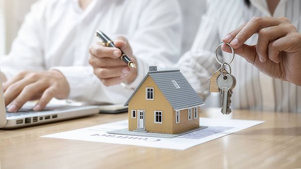 Agente imobiliário segurando uma chave e pedindo ao cliente contrato para comprar, obter seguro ou empréstimo imobiliário ou imobiliário. - Foto, Imagem