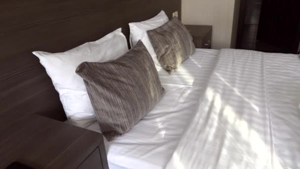 Hermosa habitación de hotel con una cama queen size con almohadas y ropa de cama fresca
 - Imágenes, Vídeo