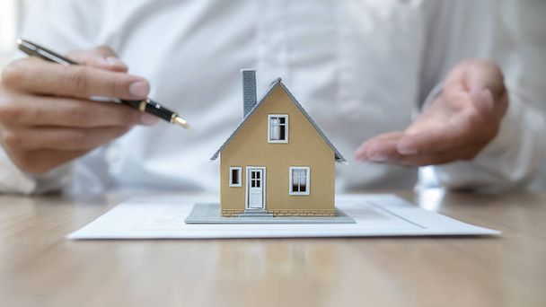 Ház modell ügynök kéri a vevő szerződés megvásárlására, kap biztosítási vagy kölcsön ingatlan vagy ingatlan. - Fotó, kép
