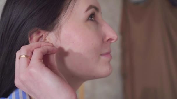 portrait positive young woman uses ear cleaning hygienic cotton swabs - Video, Çekim