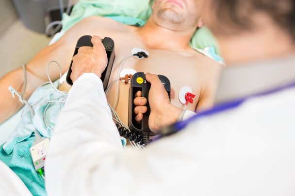 Doctor Defibrillating Male Patient In Hospital - Fotoğraf, Görsel