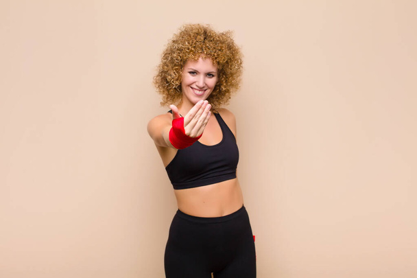 young afro woman feeling happy, successful and confident, facing a challenge and saying bring it on! or welcoming you sport concept - Zdjęcie, obraz