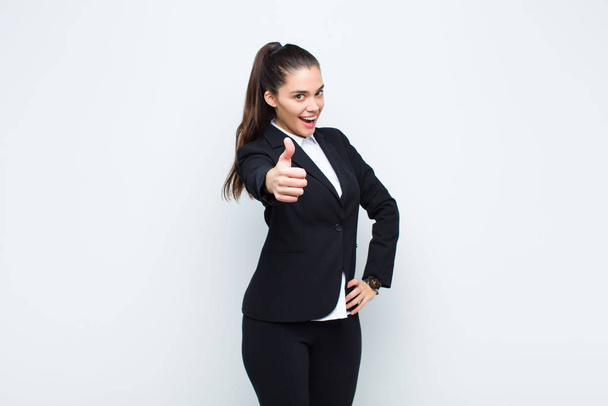 young pretty woman feeling proud, carefree, confident and happy, smiling positively with thumbs up business concept - Fotoğraf, Görsel