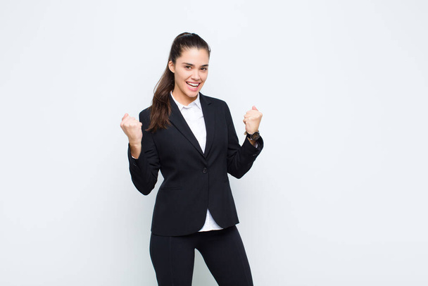 young pretty woman shouting triumphantly, laughing and feeling happy and excited while celebrating success business concept - Photo, Image