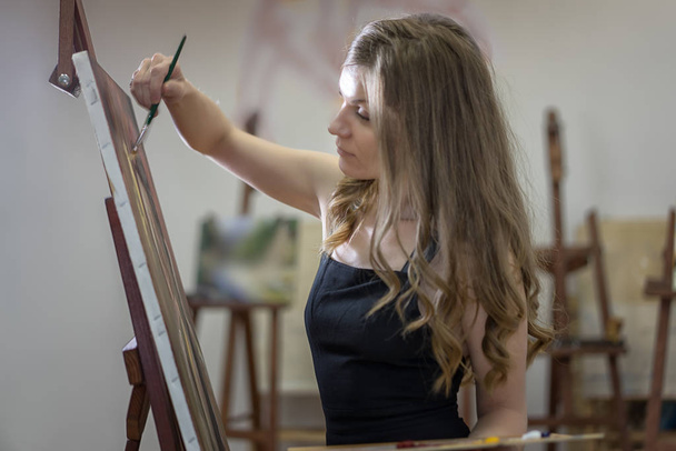 Portret van een kunstenares in het atelier. - Foto, afbeelding