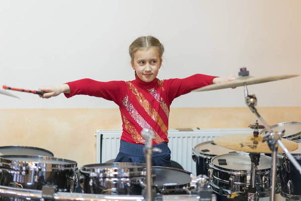 Дівчина-підліток грає на барабанах у музичному класі
. - Фото, зображення