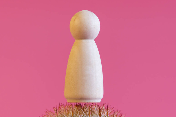 Figurine of person on the needles of cactus. Concept of pain.  - Photo, Image