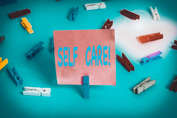 Text sign showing Self Care. Business photo showcasing practice of taking action to preserve or improve ones own health Colored clothespin papers empty reminder blue floor background office pin - Photo, Image