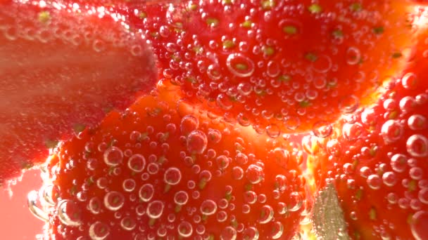 Червона полуниця чудово занурюється у воду з бульбашками. - Кадри, відео