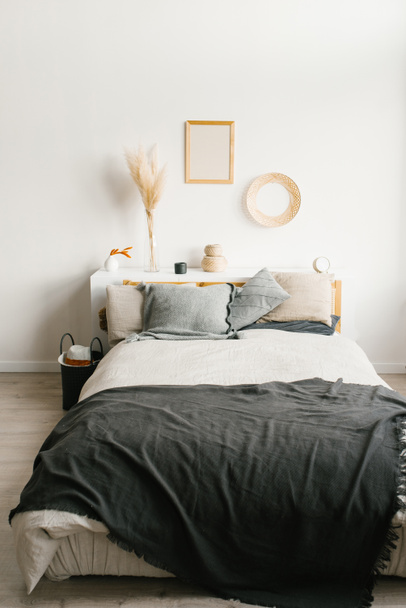 Cama en el dormitorio en un estilo minimalista escandinavo. Pastilla gris
 - Foto, Imagen