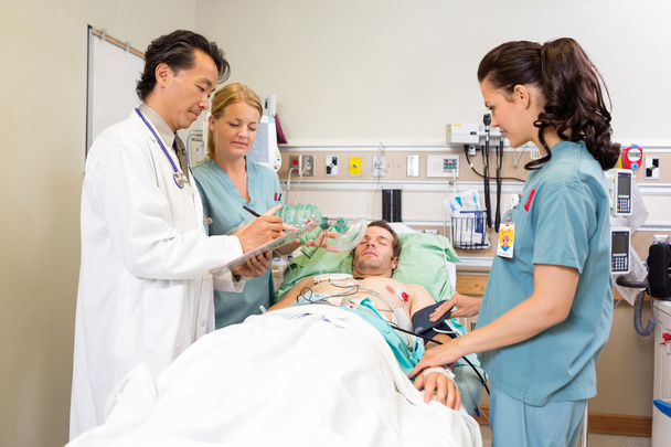 медицинская команда, осматривающая пациента в больнице
 - Фото, изображение