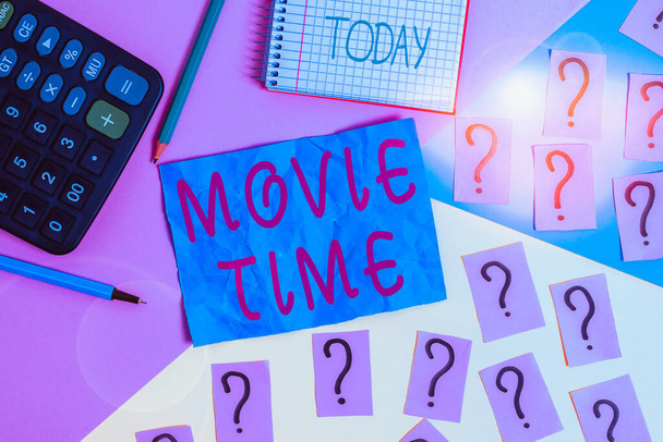Handwriting text writing Movie Time. Conceptual photo the scheduled or actual time at which a show or film begins Mathematics stuff and writing equipment above pastel colours background - Photo, Image