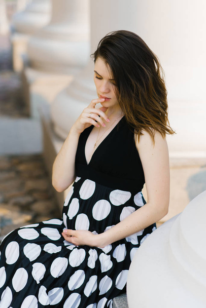 Krásná stylová mladá těhotná žena drží její ruku na její s - Fotografie, Obrázek