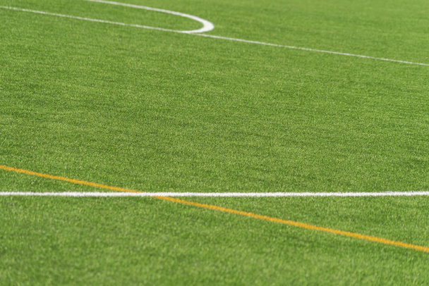 Yeşil yapay çimen sahası futbol sahası arka planı beyaz ve sarı çizgi sınırlı. Üst görünüm - Fotoğraf, Görsel