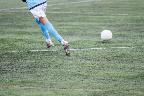 Nierozpoznawalne męskich piłkarzy grających w grę na boisku do piłki nożnej. - Zdjęcie, obraz