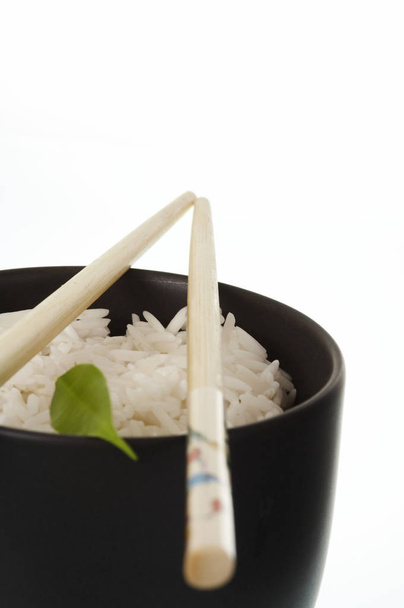 bowl of rice with chopsticks on white background - Фото, изображение