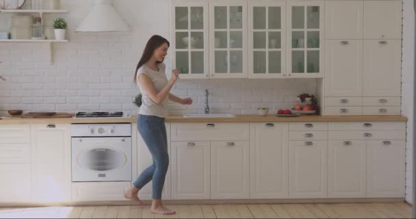 Overjoyed smiling woman having fun in kitchen while preparing breakfast. - Materiał filmowy, wideo