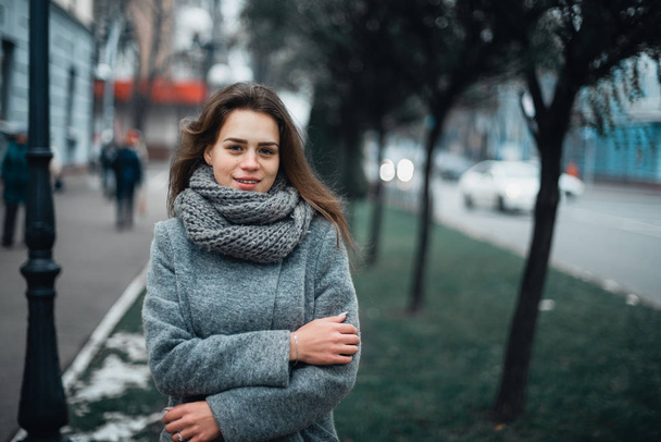 Girl in a gray coat in the winter in the city - Foto, afbeelding