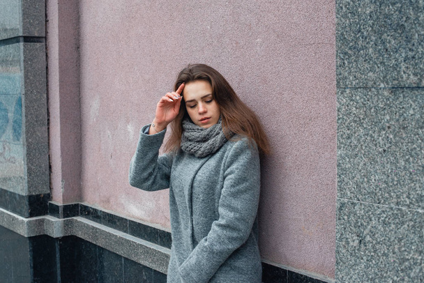 Girl in a gray coat in the winter in the city - Foto, afbeelding