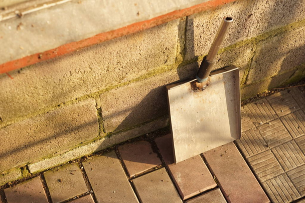homemade dustpan is standing against the wall of the house on the tiled floor of the courtyard. - Foto, immagini