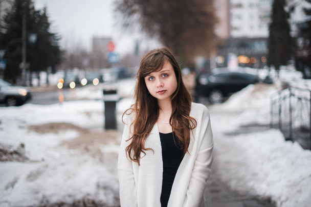 Girl in winter in a cardigan on a street in the city - Foto, afbeelding