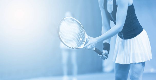 Close-up de mulher está segurando raquete de tênis no campo de tênis duro. Filtro azul
 - Foto, Imagem